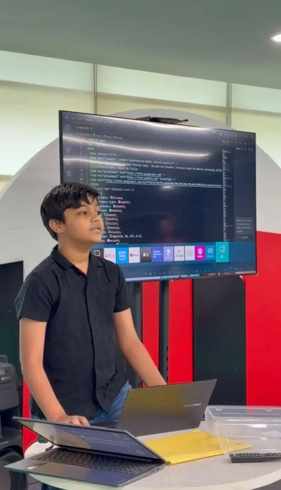 Student presenting a web page's HTML code on a large classroom screen